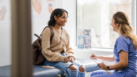 Female adolescent patient talking with doctor